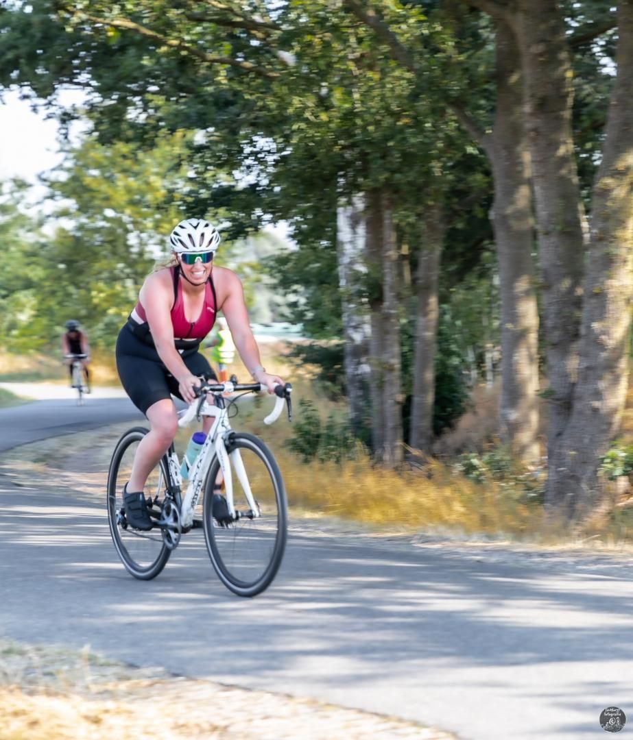 Een vrouw fietst over een weg.