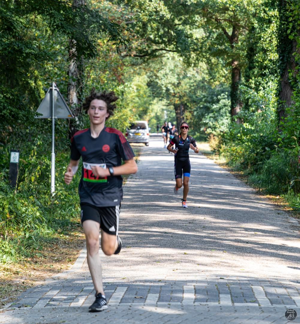 Een groep mensen rent over een weg.