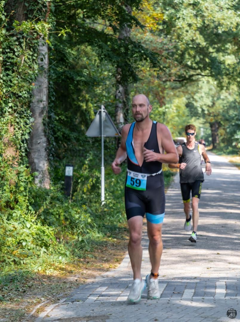 Een man met rugnummer 39 rent over de weg.