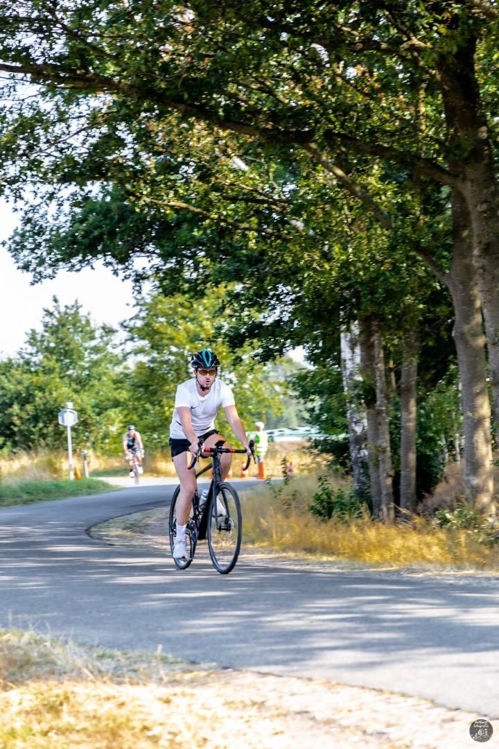 Een man fietst over een landweg.