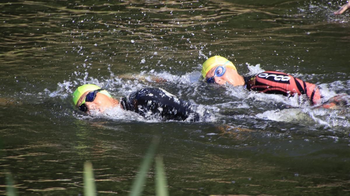 Een paar mensen zwemmen in een meer.