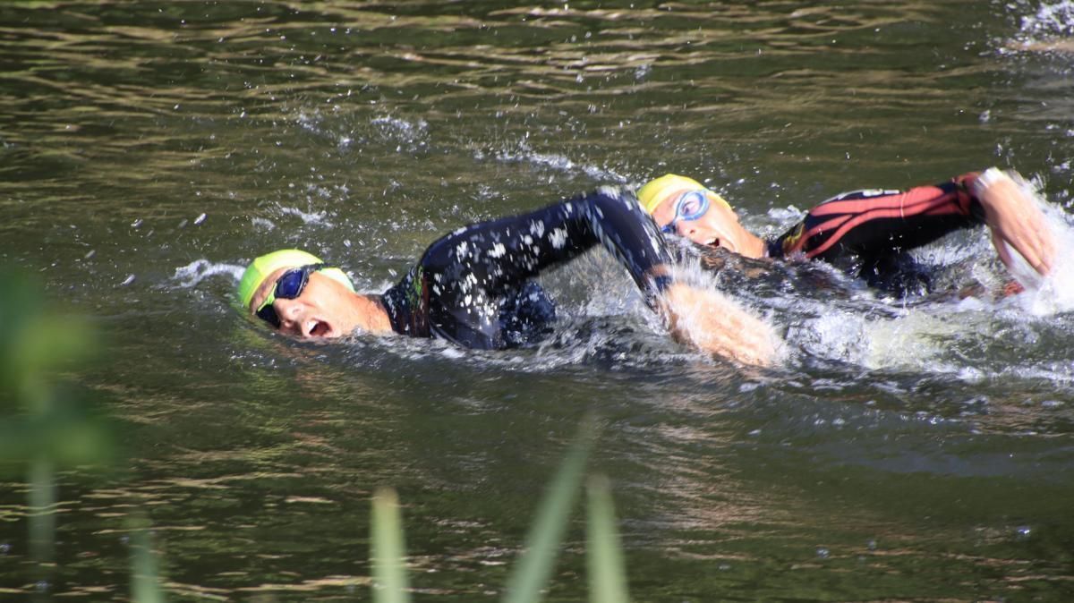 Twee mensen zwemmen in een watermassa.