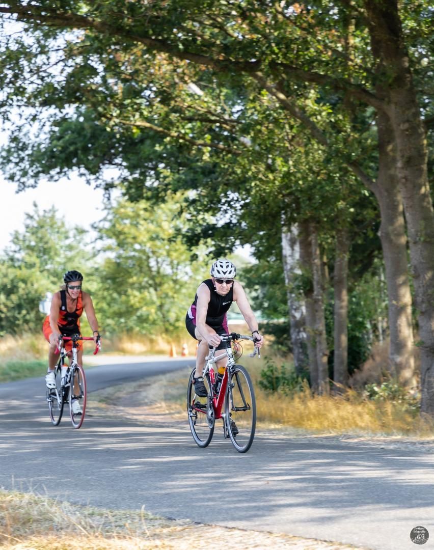 Twee mensen fietsen over een weg.