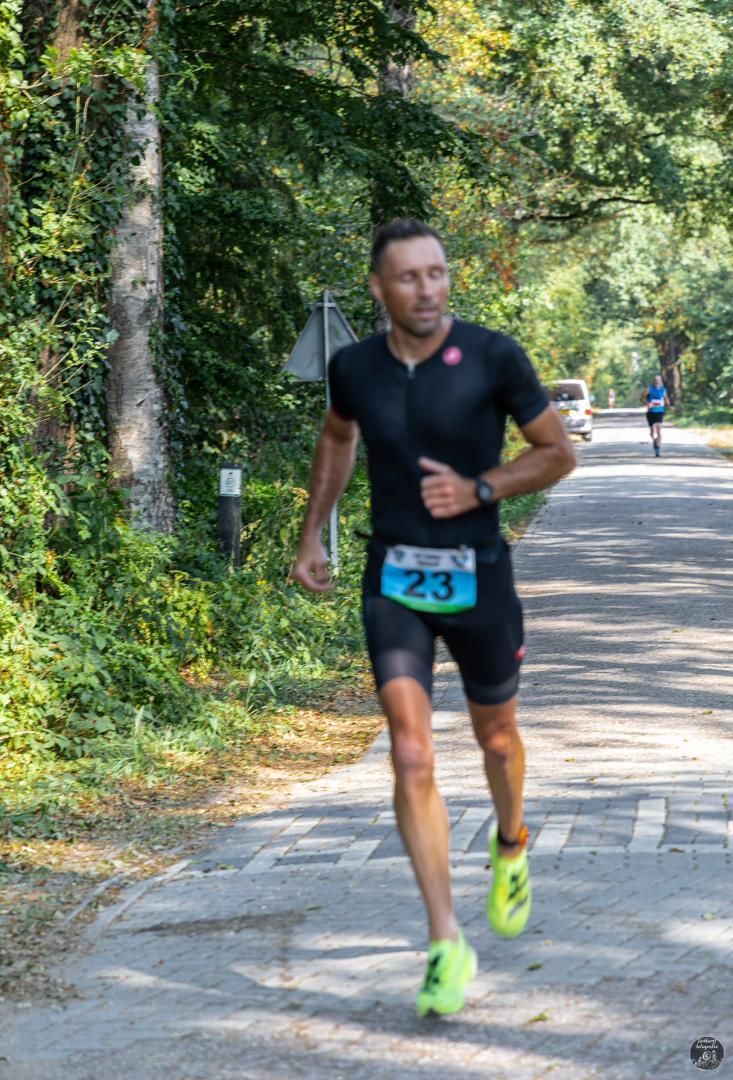 Een man rent over de weg tijdens een triatlon.