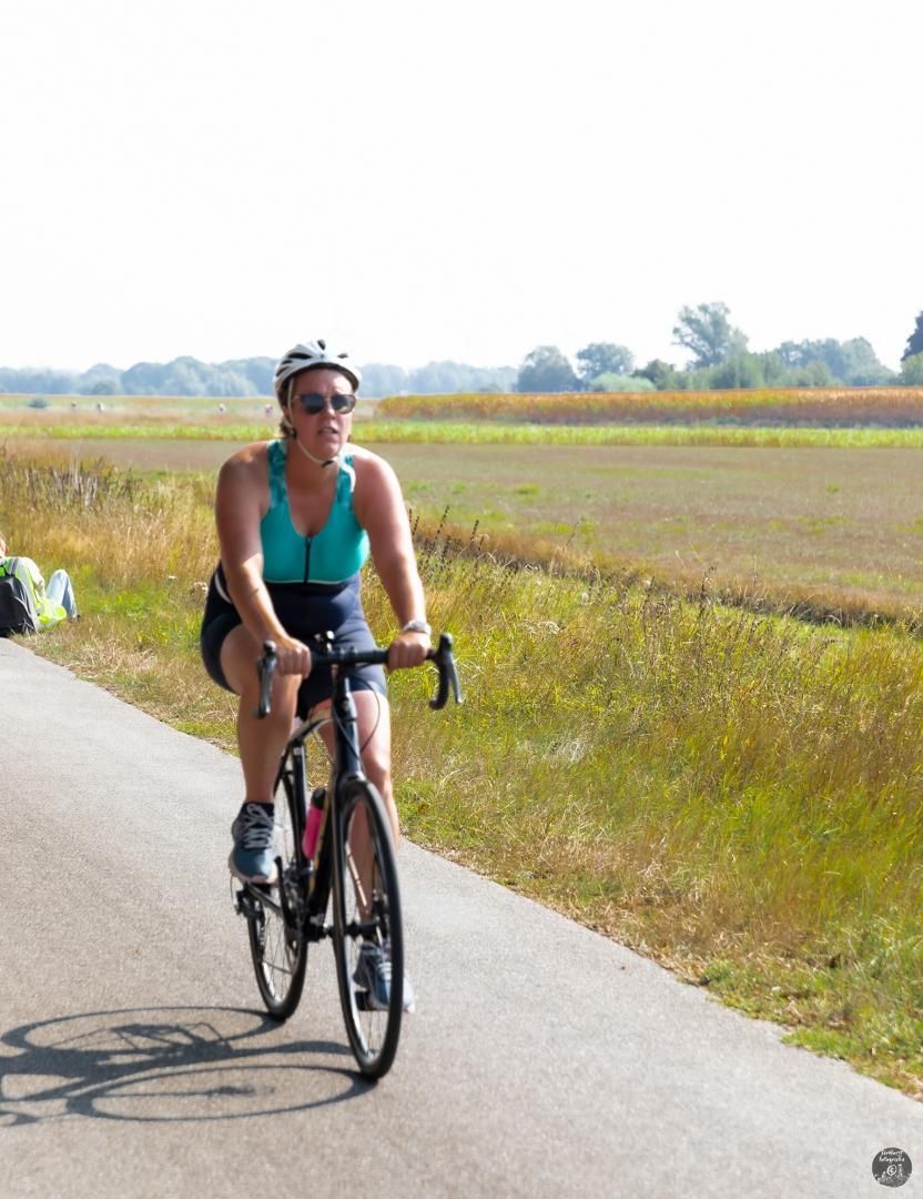 Een vrouw fietst over een weg.