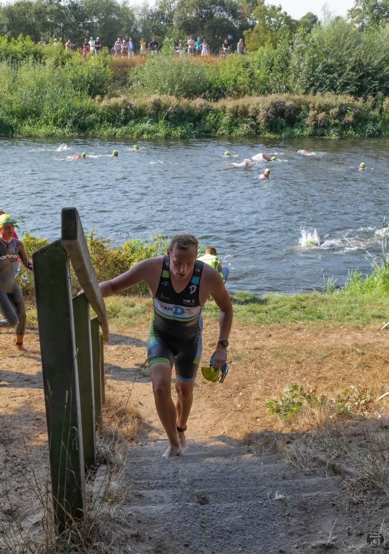 Een man loopt een trap op richting een watermassa.