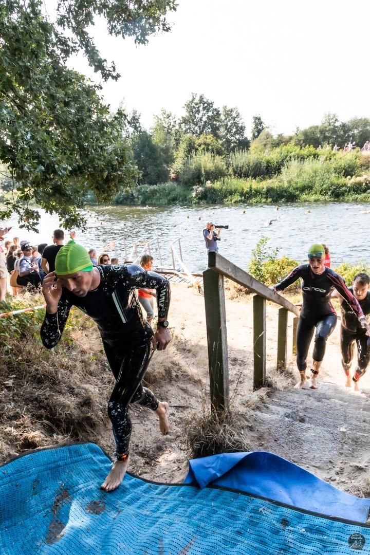 Een groep mensen rent de trap op richting een meer.