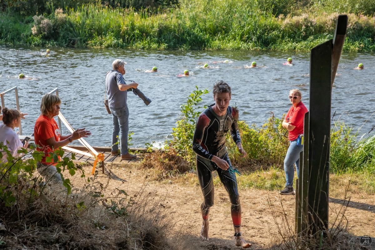 Een man in een wetsuit rent naar een watermassa.