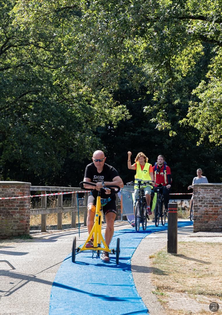 Een groep mensen fietst op een blauw pad.