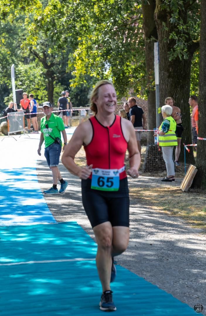 Een vrouw doet mee aan een wedstrijd met nummer 65 op haar startnummer.