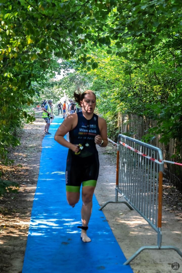 Een vrouw rent op een blauw tapijt in het bos.