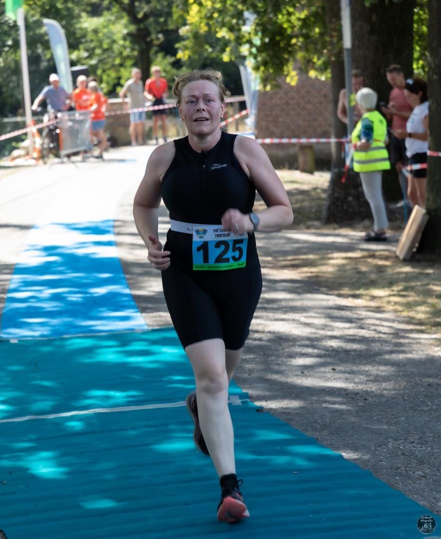 Een vrouw rent met het nummer 125 op haar startnummer