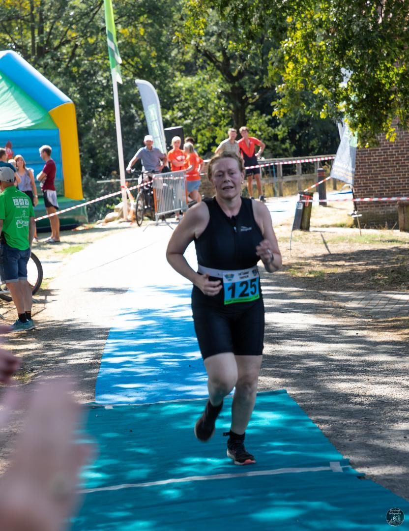 Een vrouw rent mee in een race met het nummer 125 op haar shirt