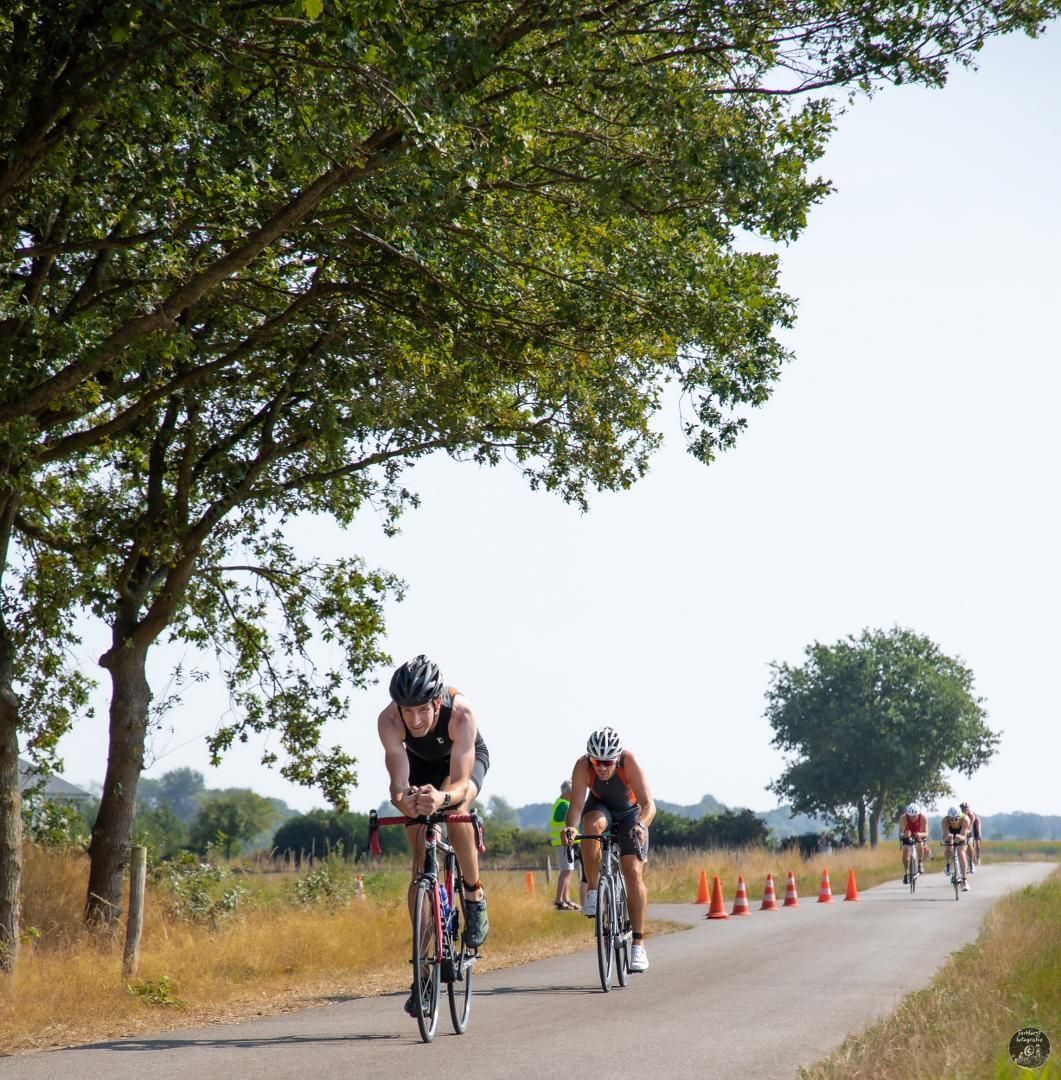 Een groep mensen fietst over een weg