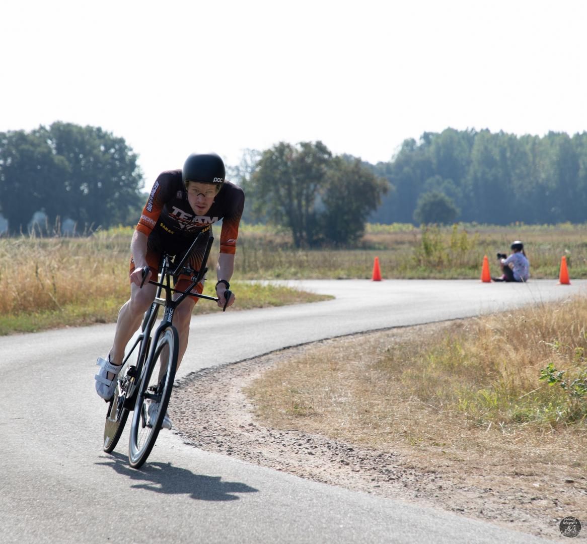 Een persoon die op een fiets over een weg rijdt met een Texas-shirt aan