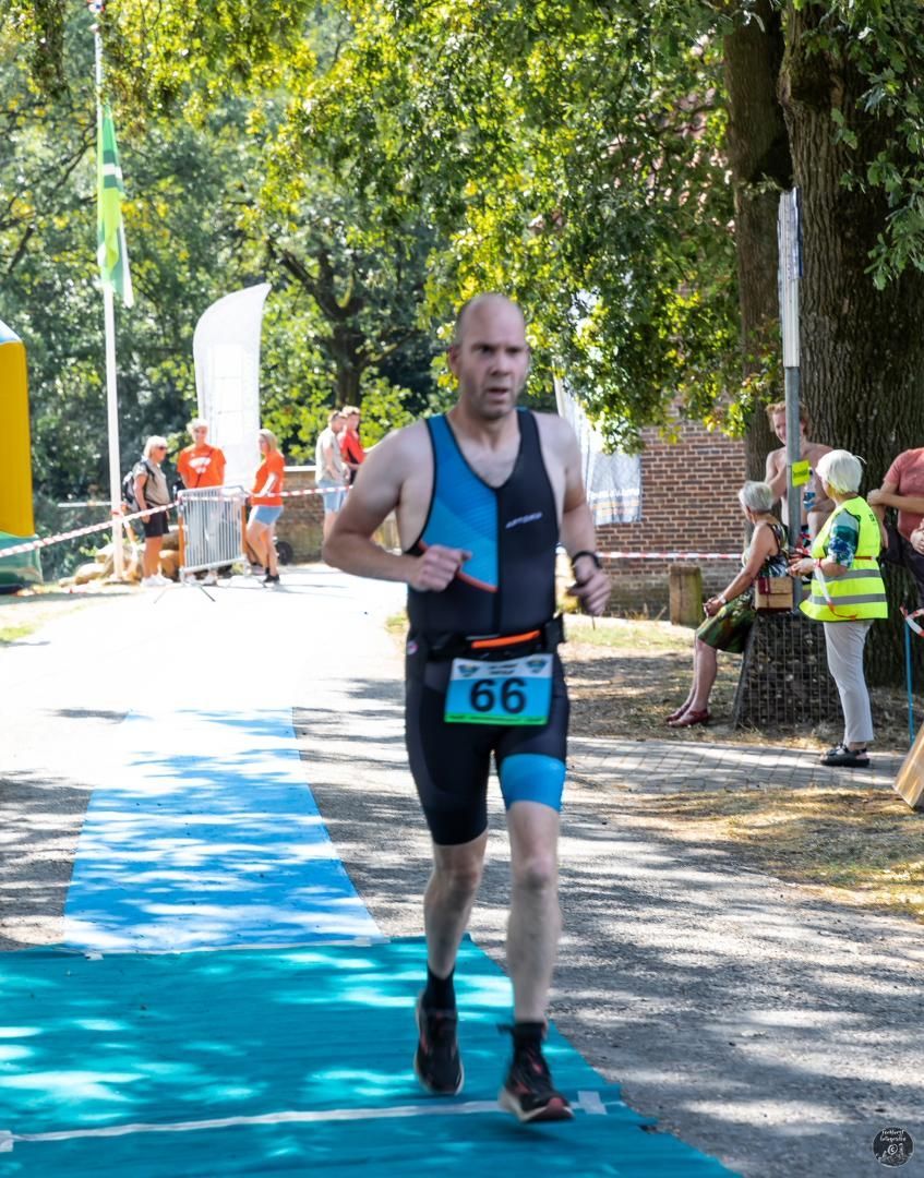 Een man doet mee aan een race met het nummer 66 op zijn startnummer.