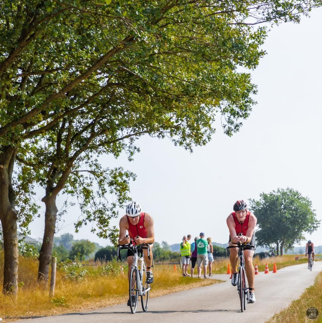 Twee mannen rijden op hun fiets over een weg