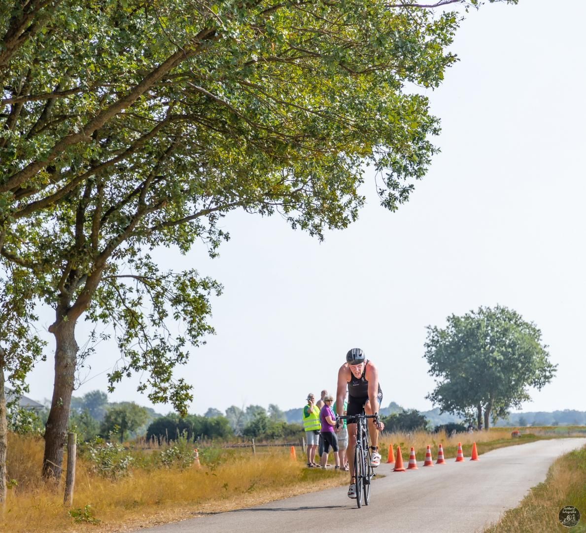 Een man fietst over een landweg.