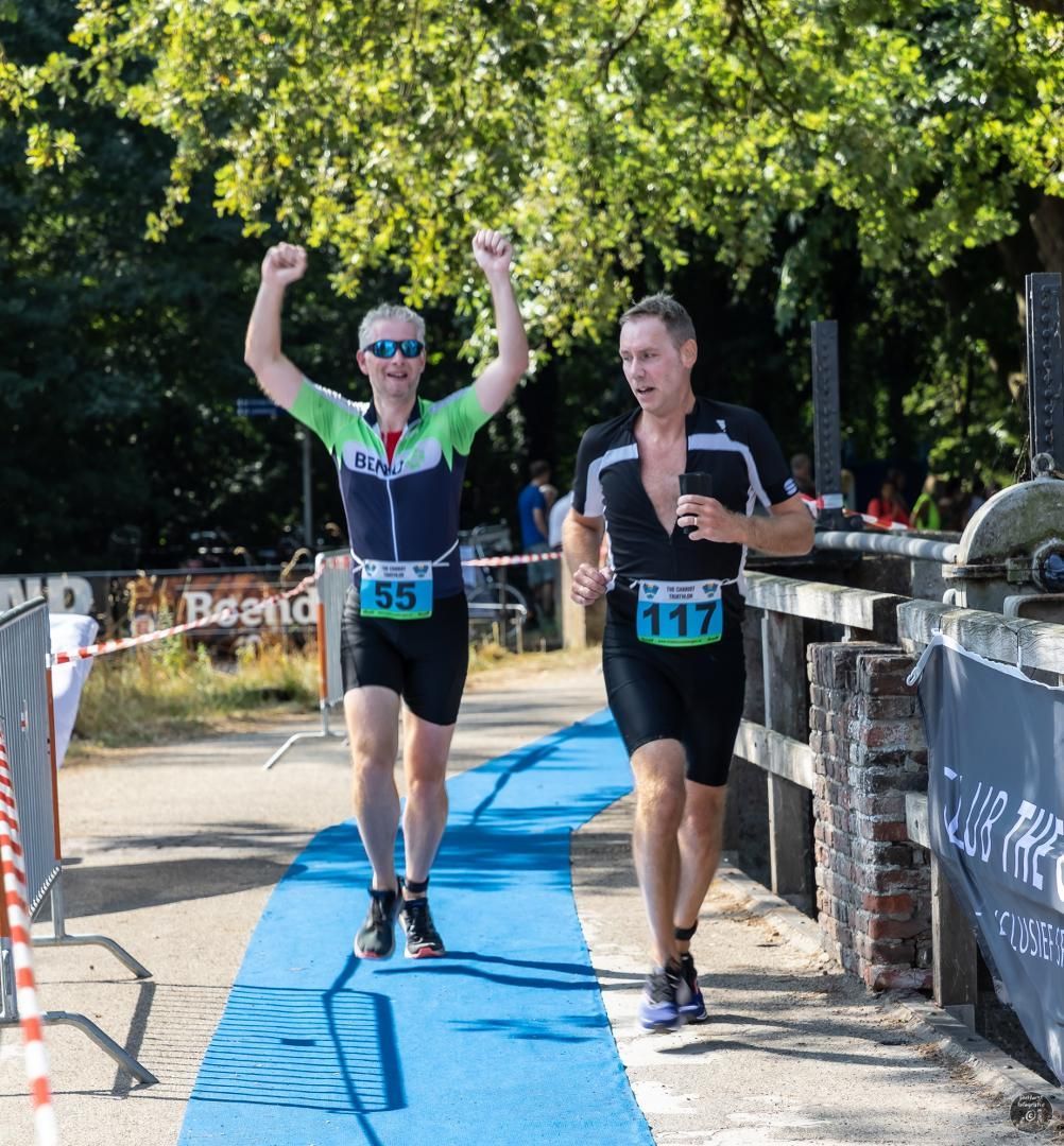 Twee mannen rennen in een race en een van hen heeft het nummer 117 op zijn startnummer