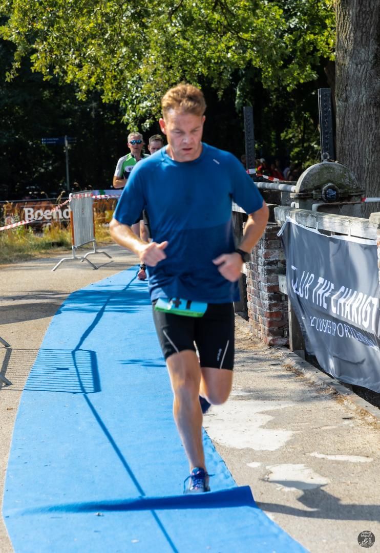 Een man in een blauw shirt rent op een blauwe mat