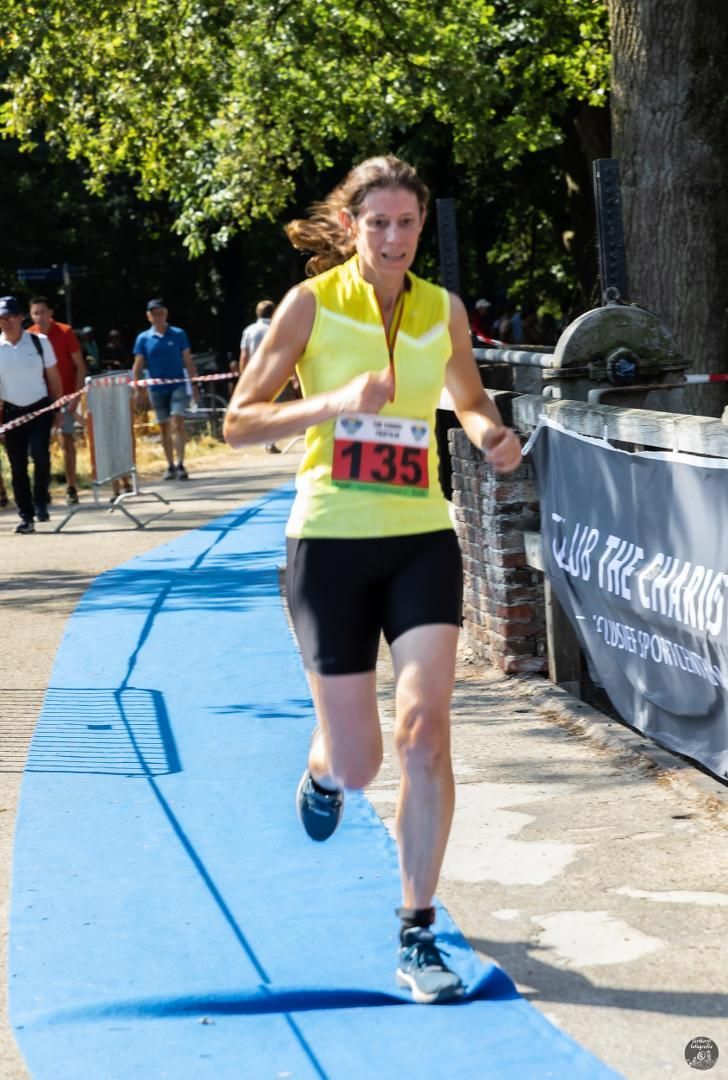 Een vrouw rent mee in een race met het nummer 135 op haar shirt