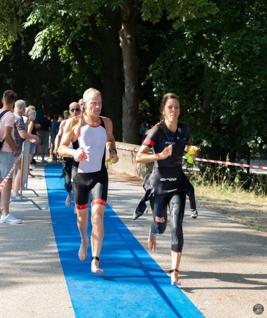 Een groep mensen rent over een blauwe loper