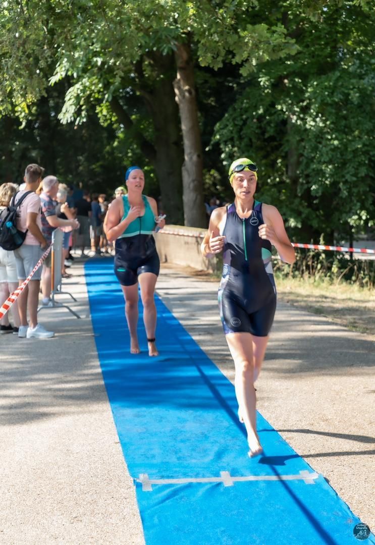 Een groep mensen rent over een blauwe loper.