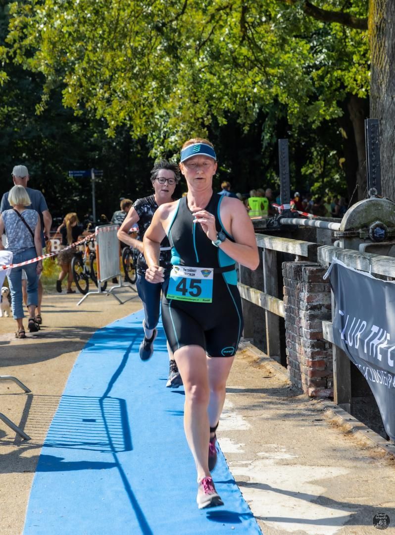 Een vrouw rent mee in een triatlon met nummer 45 op haar shirt.