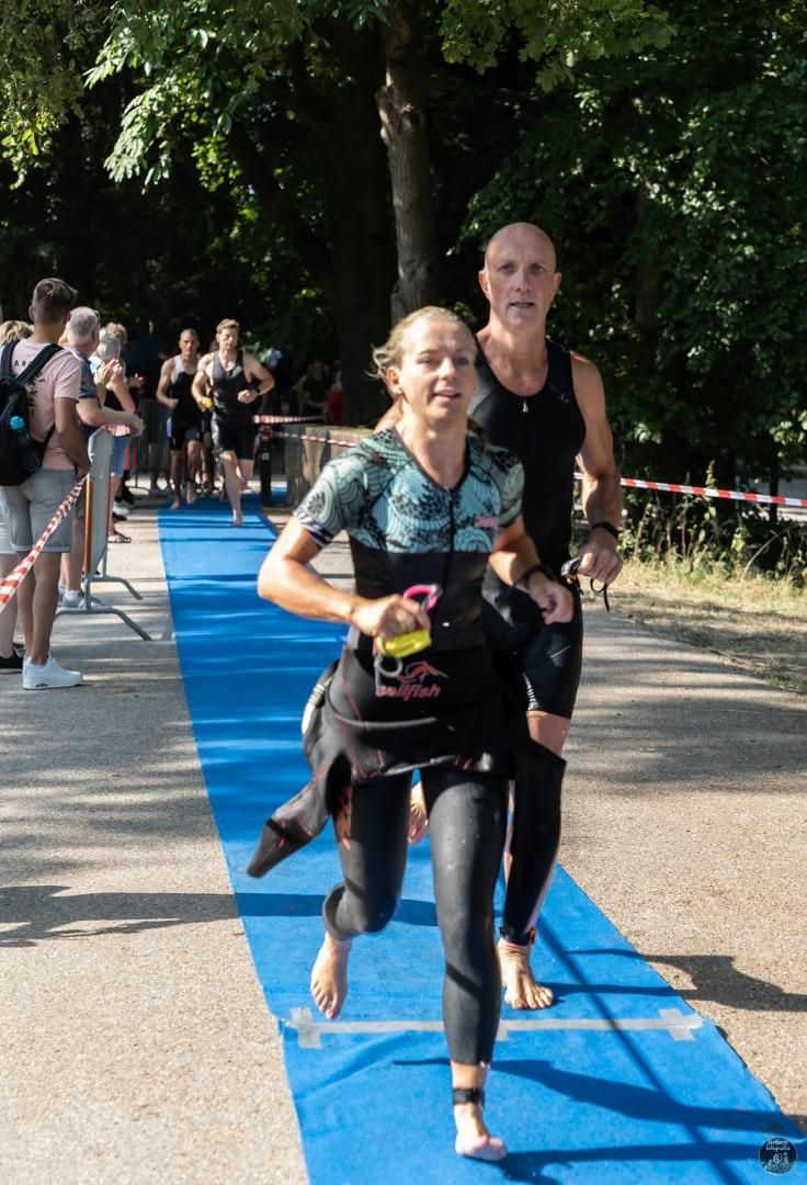 Een man en een vrouw rennen over een blauwe loper