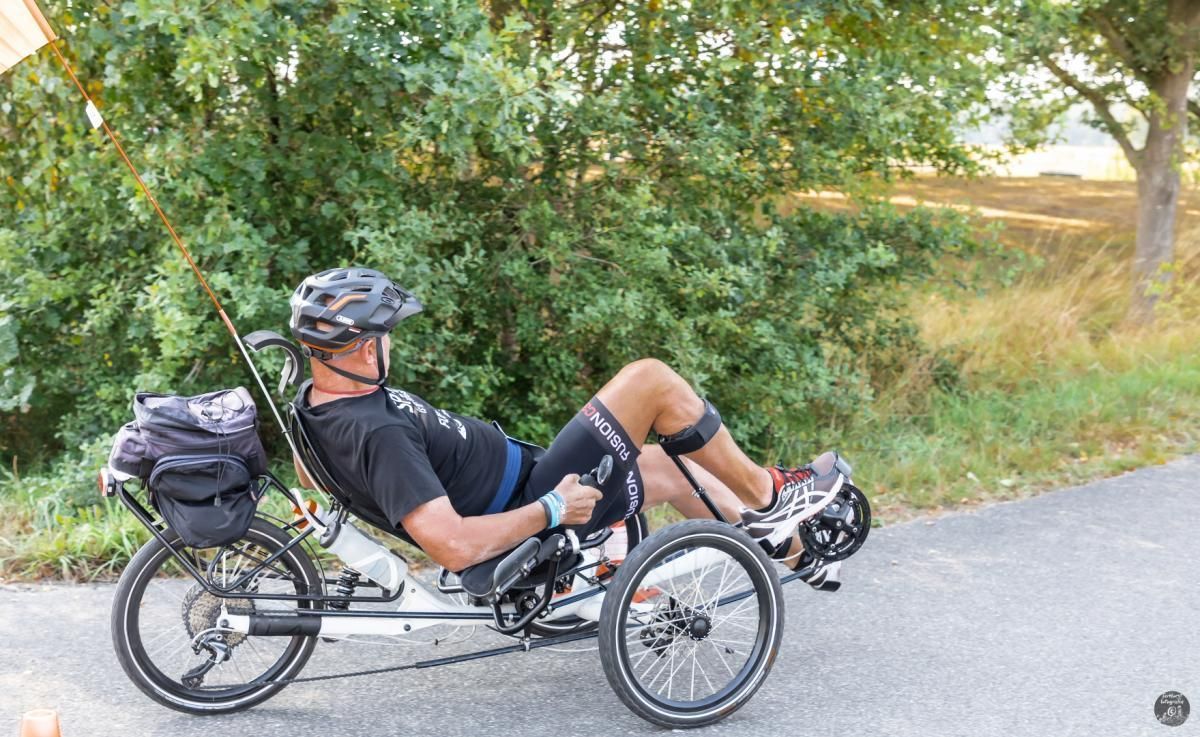 Een man rijdt op een ligfiets op de weg.