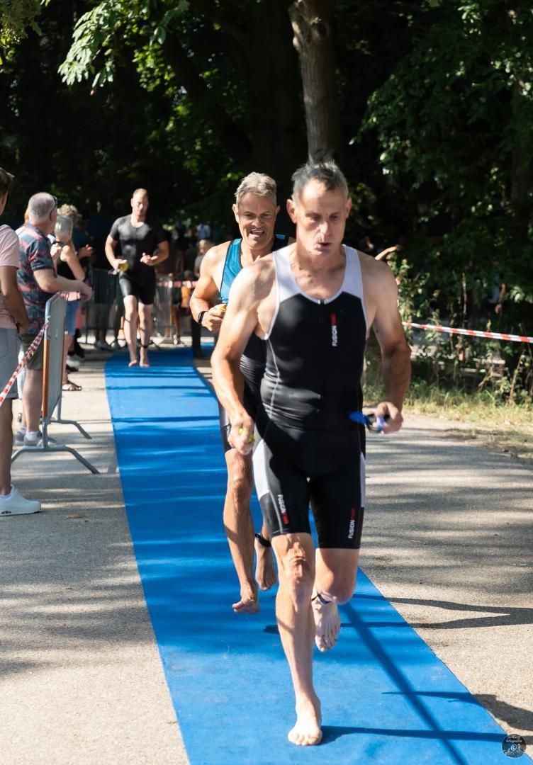 Een groep mannen rent over een blauwe loper.