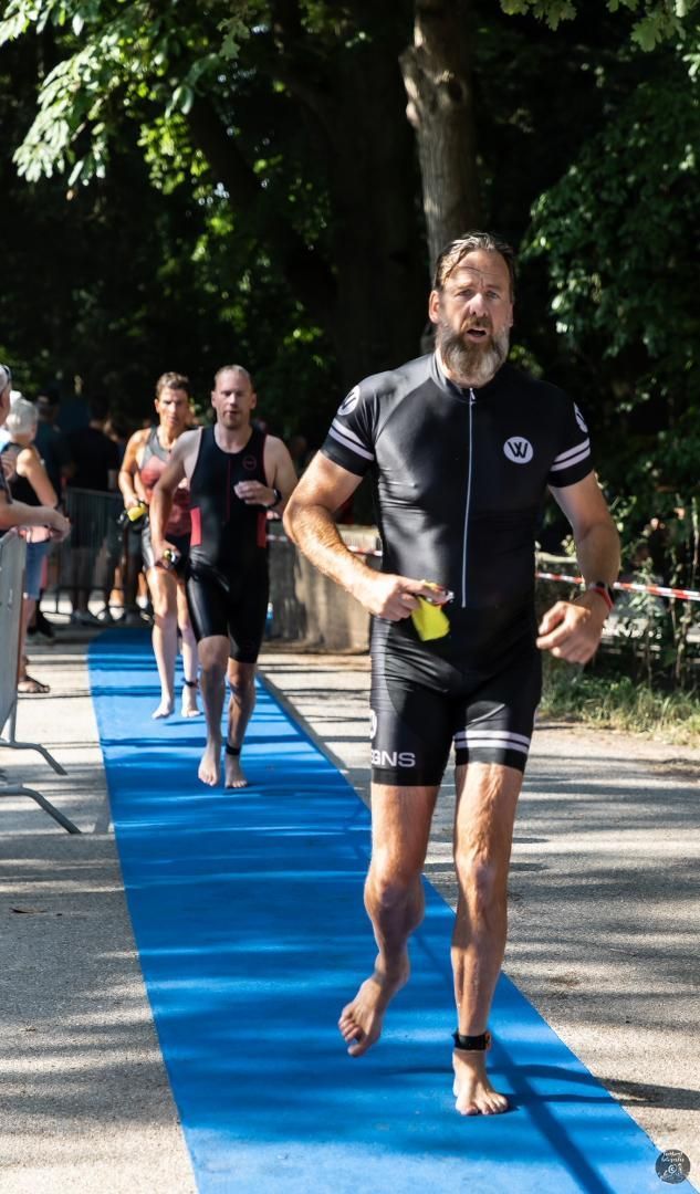 Een groep mannen rent over een blauwe loper.