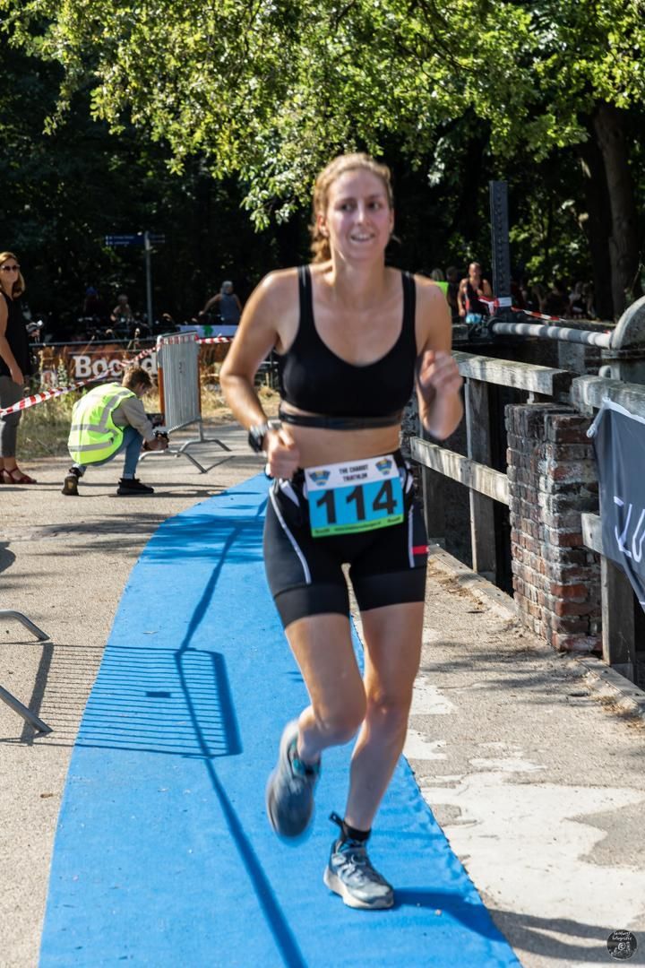 Een vrouw doet mee aan een wedstrijd met nummer 114 op haar startnummer.