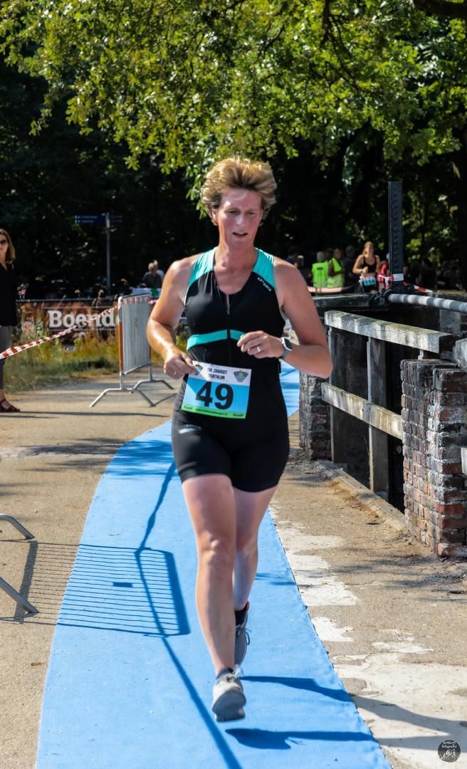 Een vrouw doet mee aan een race met nummer 49 op haar shirt.