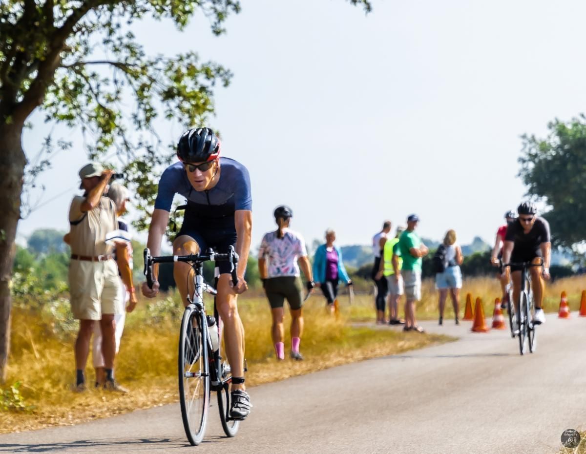 Een groep mensen fietst over een weg.