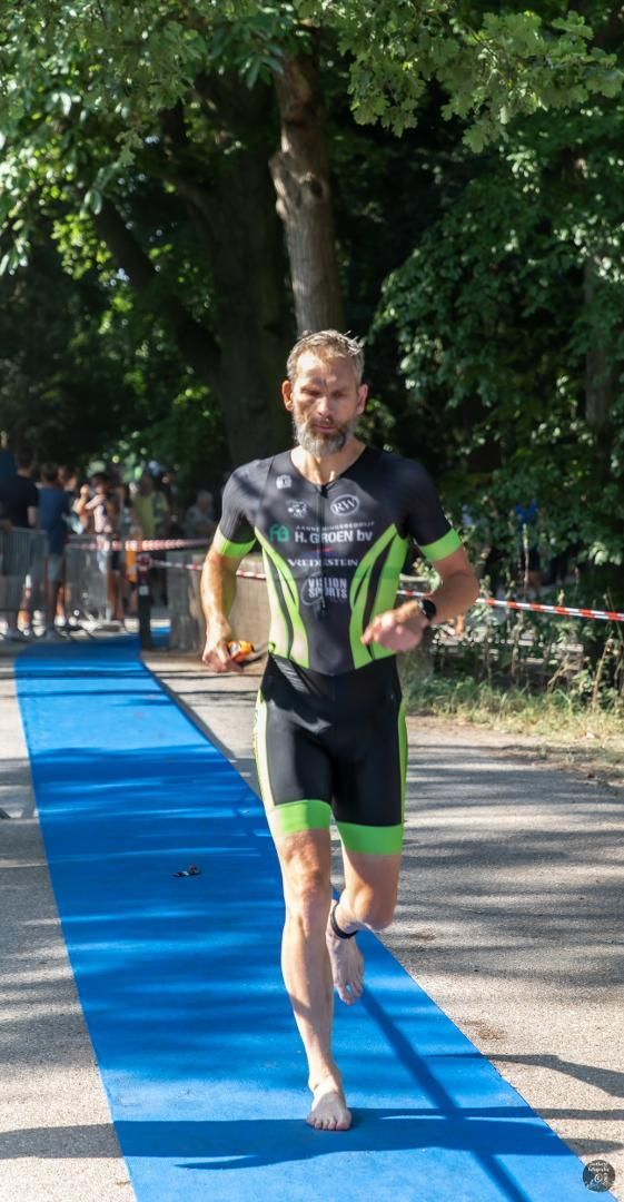 Een man rent over een blauwe loper.