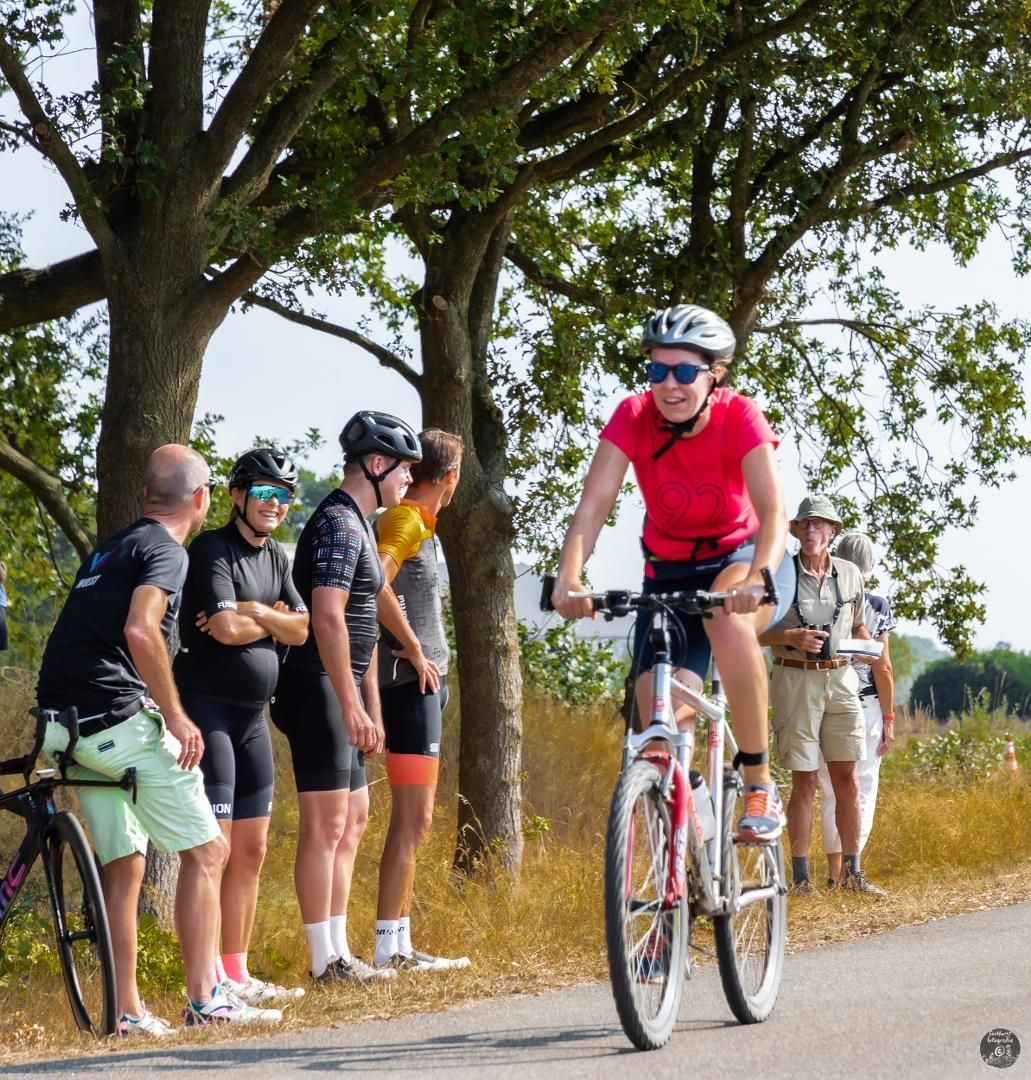 Een groep mensen kijkt naar een persoon die op een fiets rijdt