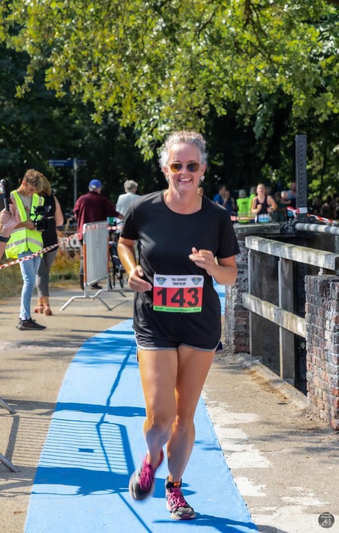 Een vrouw doet mee aan een race met een nummer op haar shirt.