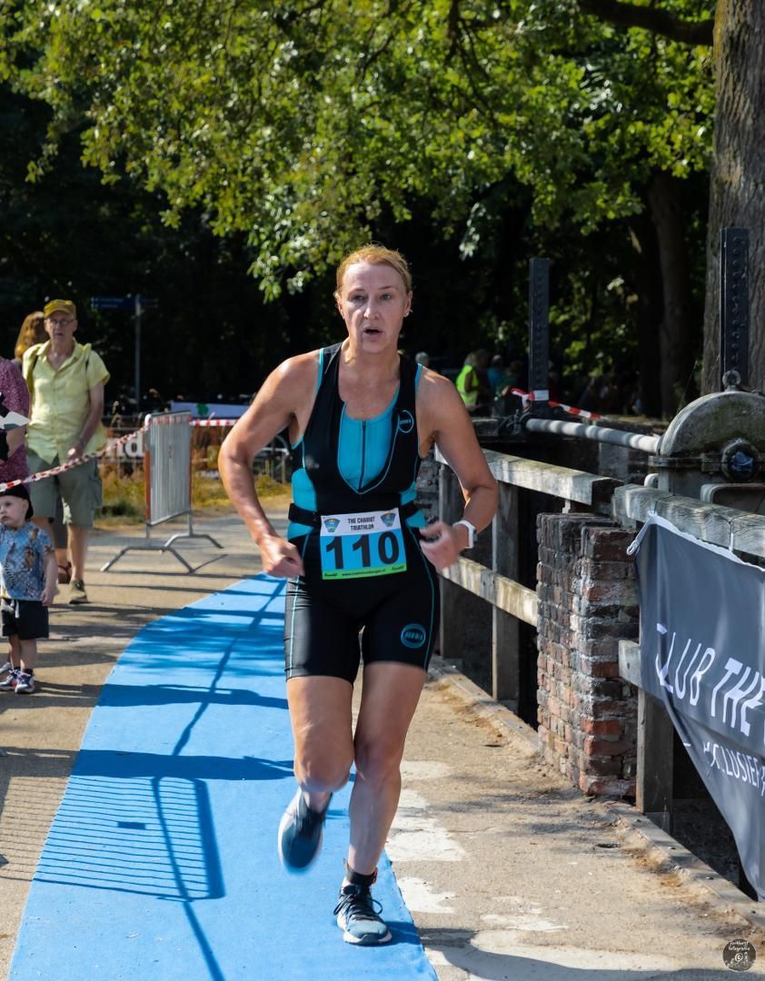 Een vrouw doet mee aan een race met het nummer 110 op haar shirt.