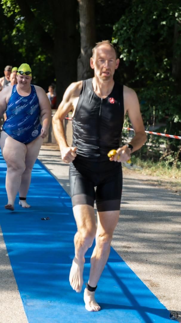 Een man en een vrouw rennen op een blauwe mat.