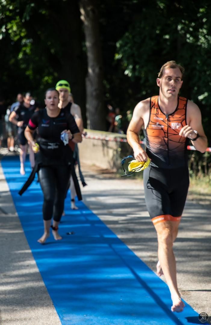 Een groep mensen rent over een blauwe loper.