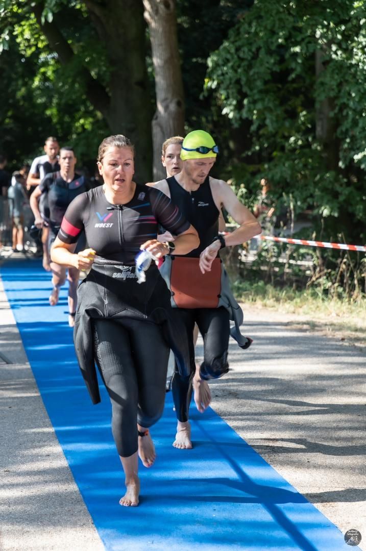 Een groep mensen rent over een blauwe loper.