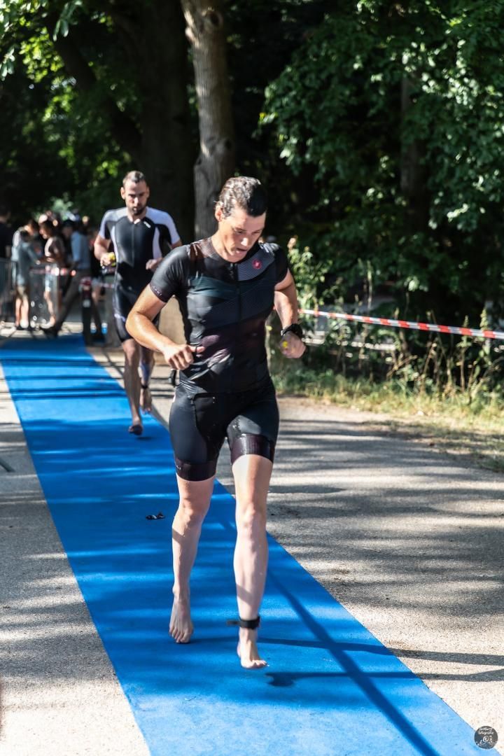 Een vrouw rent op blote voeten over een blauw tapijt.