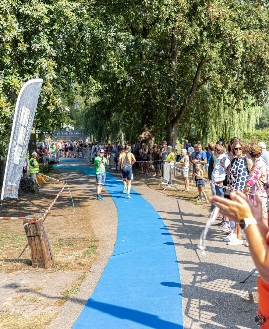 Een groep mensen staat op een blauw pad in een park.