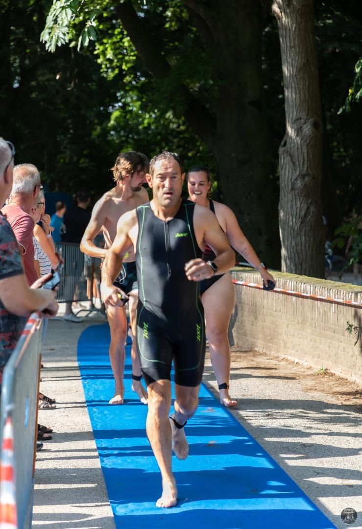 Een groep mensen rent op een blauwe mat.