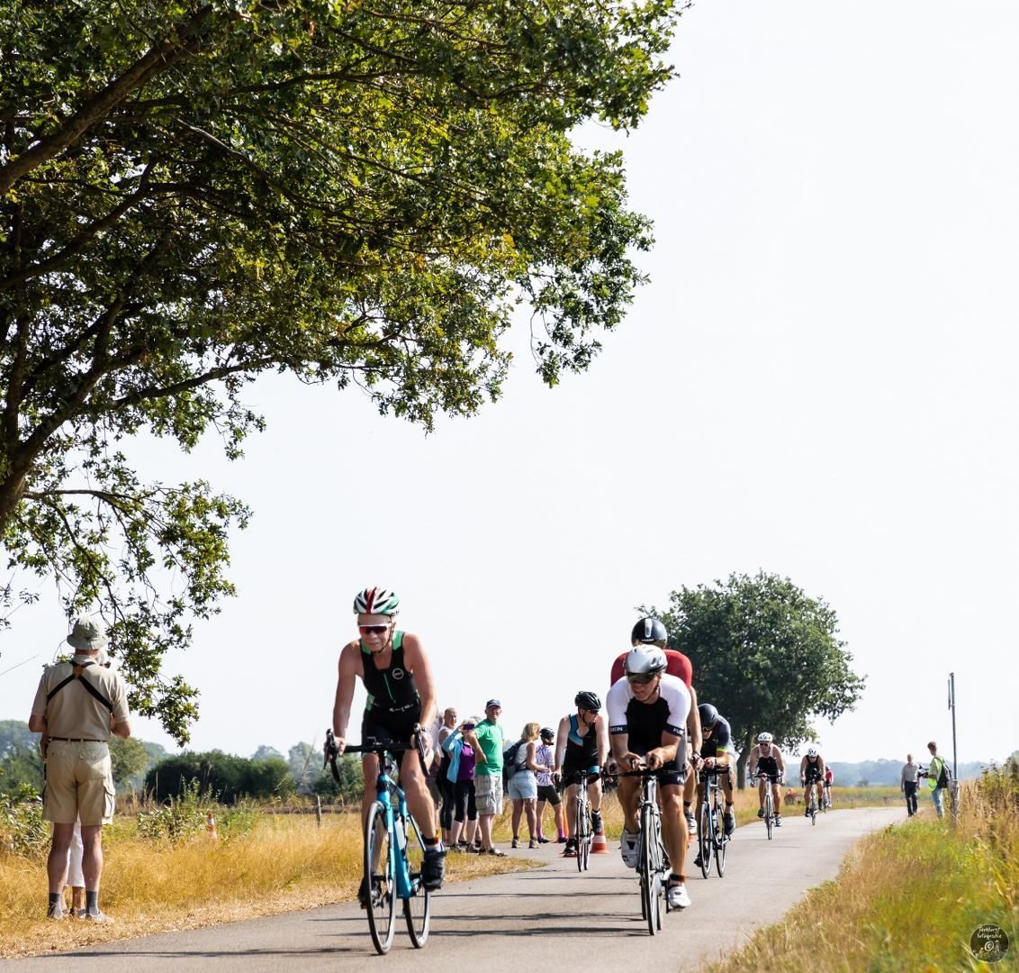 Een groep mensen fietst over een weg.
