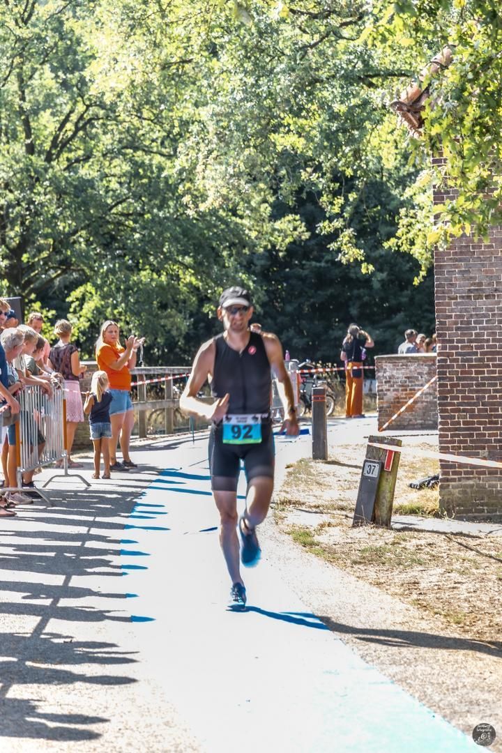 Een man rent een marathon in een park.