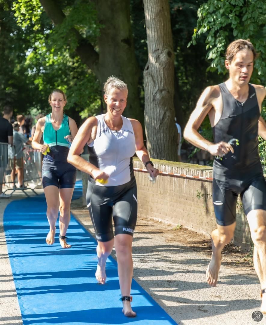 Een groep mensen rent over een blauwe loper