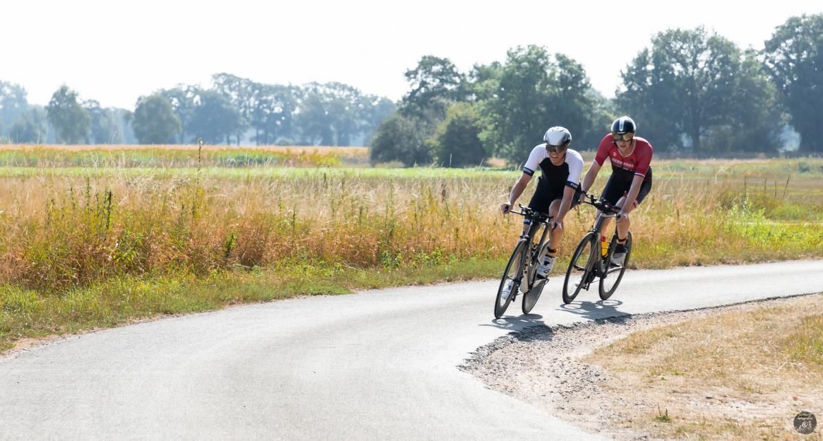 Twee mannen fietsen over een landweg.