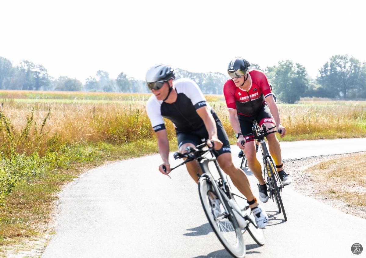 Twee mannen fietsen over een weg.